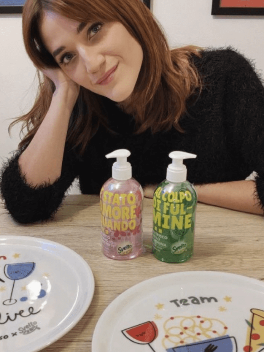 A girl showing two packaging of Svelto Pump and two promotional plates "Momusso x Svelto". Made by Caffeina for Unilever.